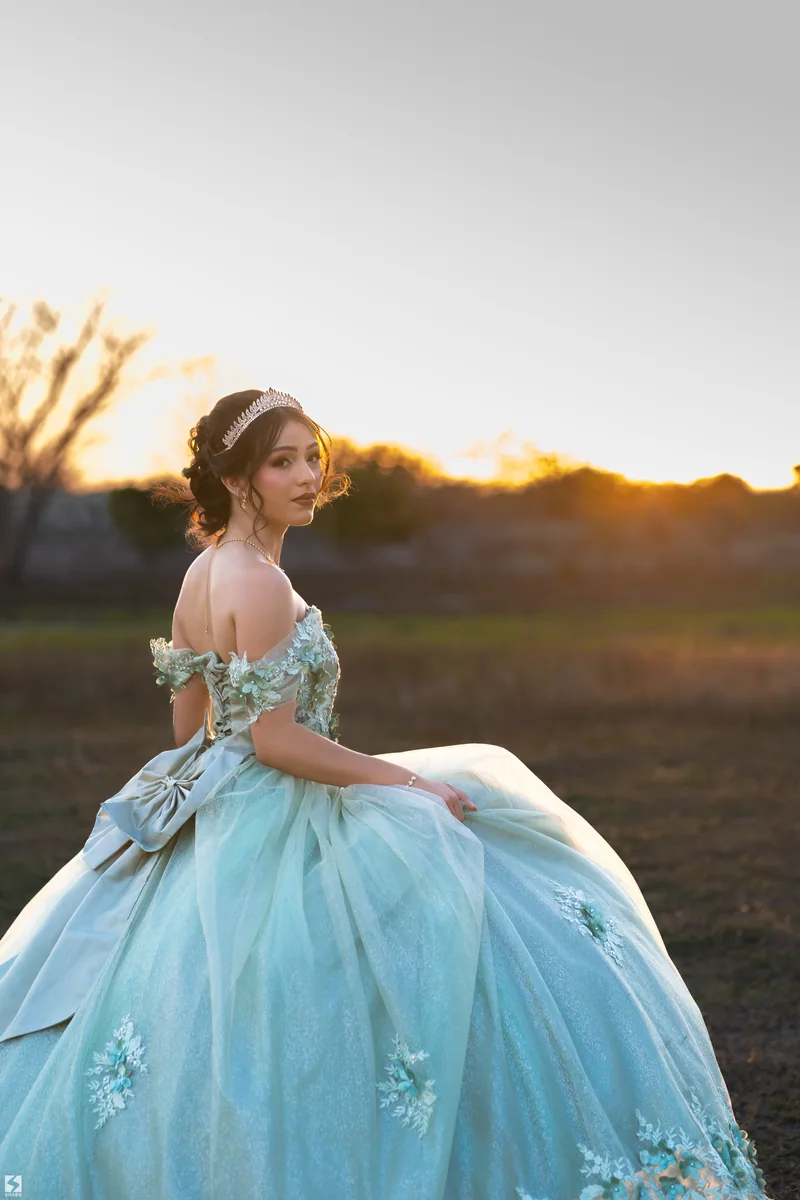 Quinceañera con vestido azul cielo al atardecer